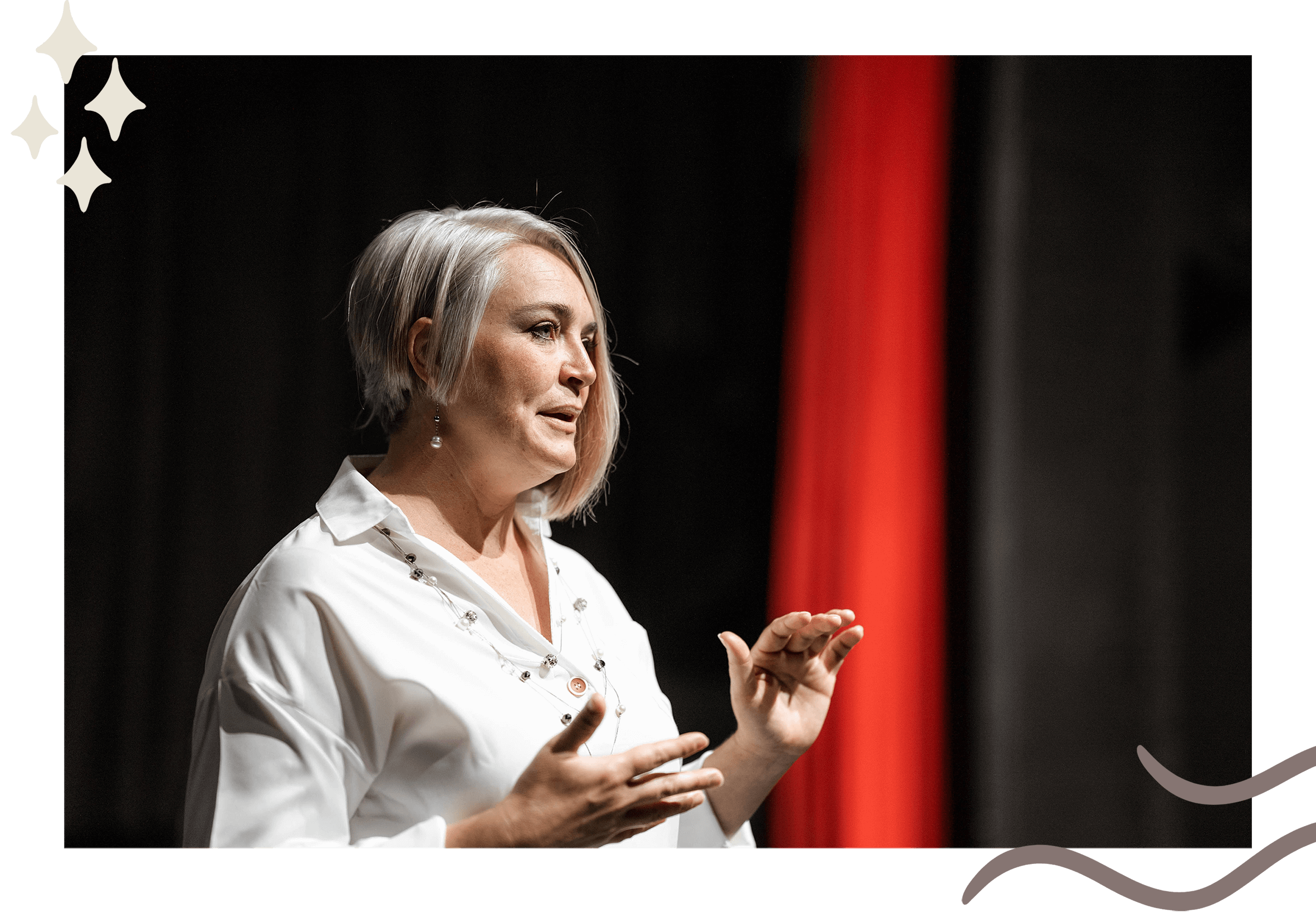 Medium shot of Krystal Jakosky in white shirt on stage with dark background