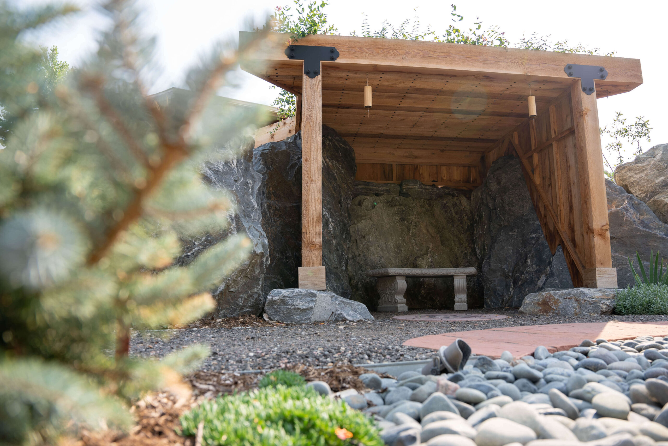 Explore the Gardens at The Beam and Bell Rock grotto with wood frame and roof