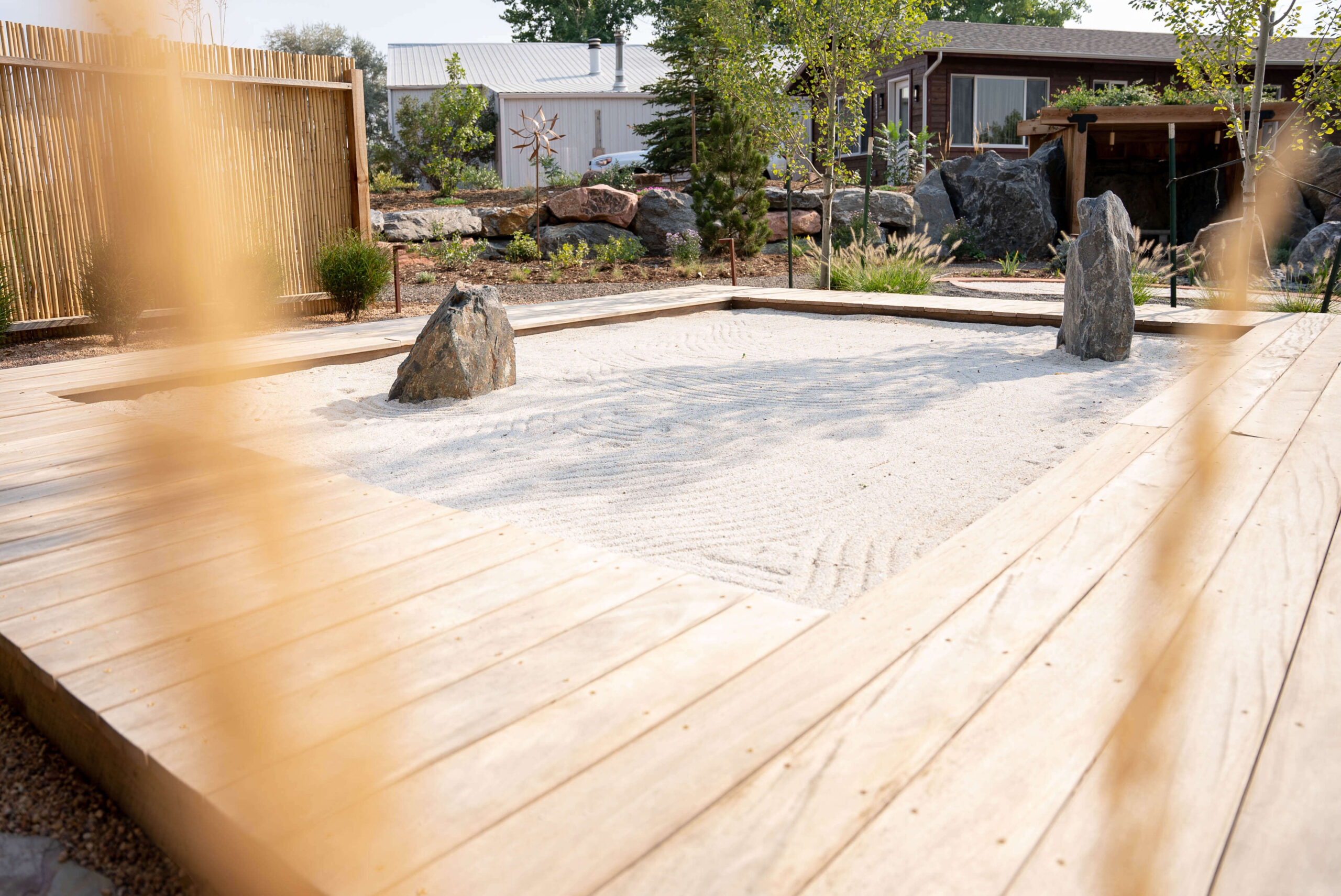 Gardens Spotlight: The Raking Garden Sand zen garden with two large boulder and wood walk way frame