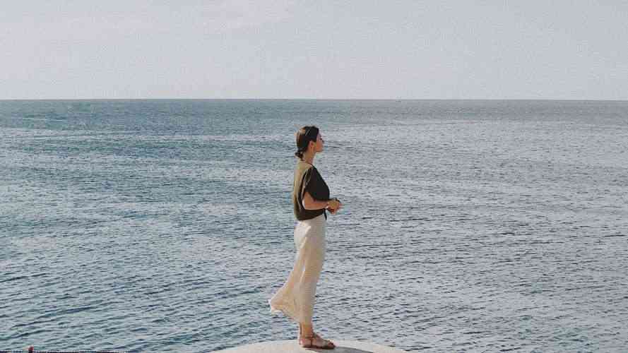 40: 3 Questions to Help You Shift Gears a woman in a white skirt standing in front of the sea