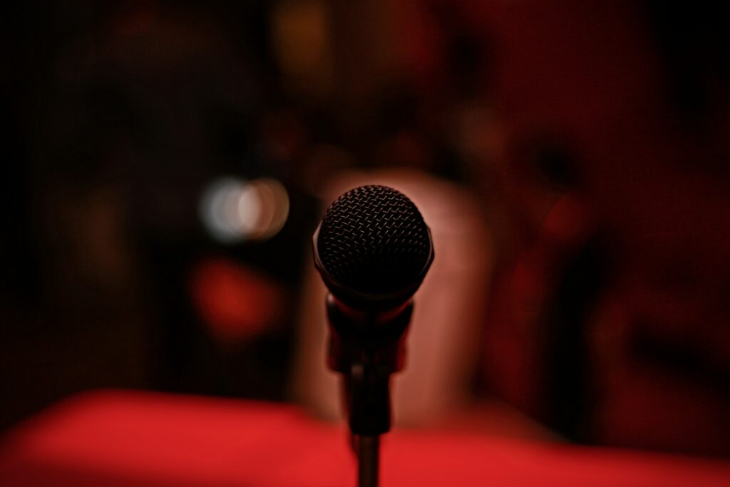 46: 5 Things I Learned at TEDWomen 2021 close up of a black microphone with a red blurred out background