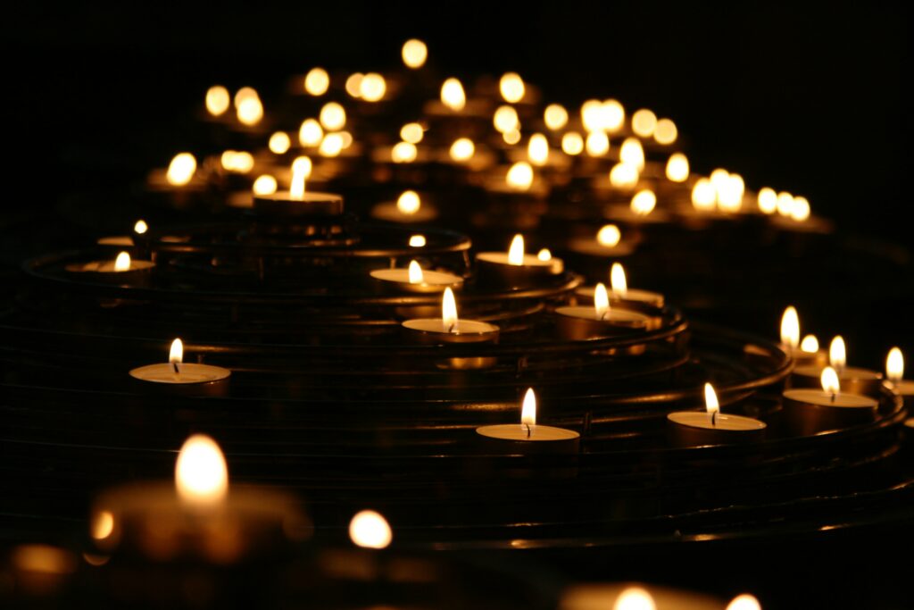 47: How to Move Forward in Grief with Erika M. Schreck several lit votive candles at night
