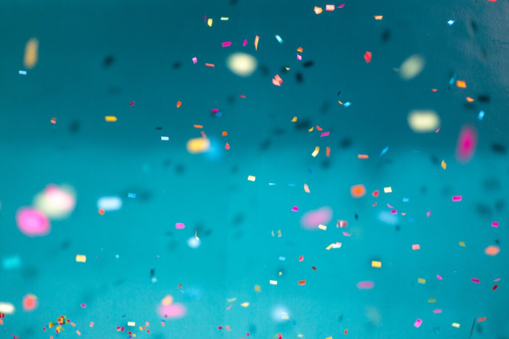 52: Happy One Year of Breathe In, Breathe Out! close up of blue background with rainbow confetti