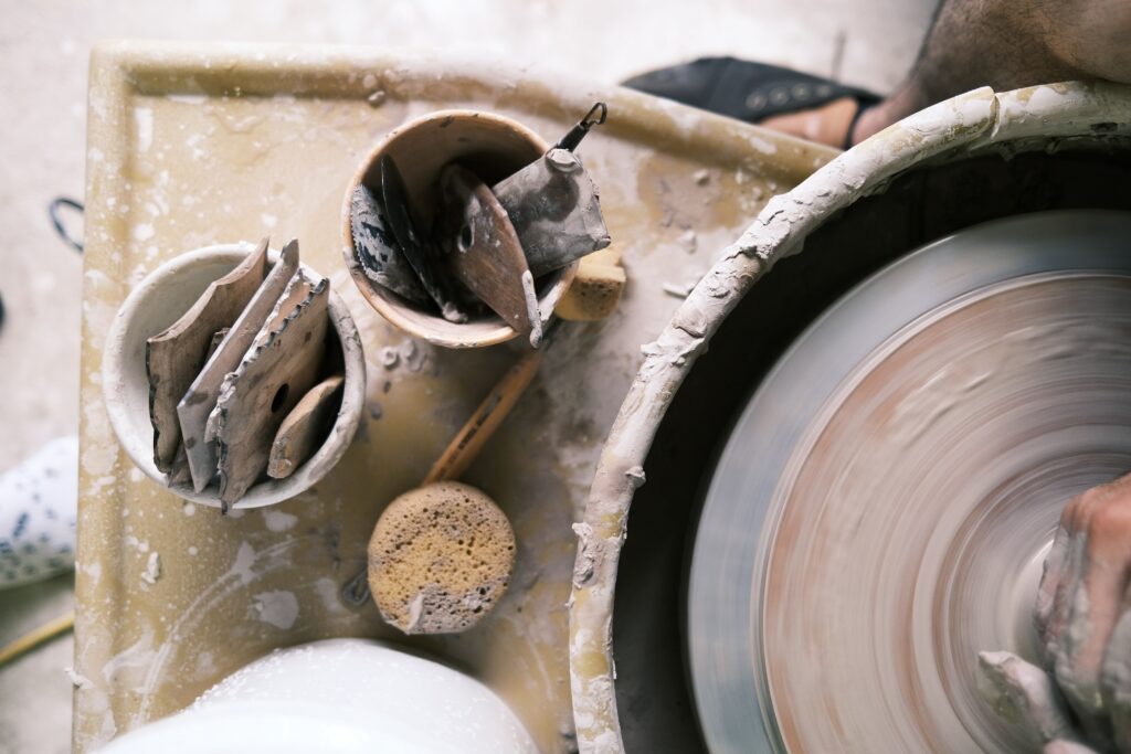 close up of a table with pottery tools and a pottery wheel