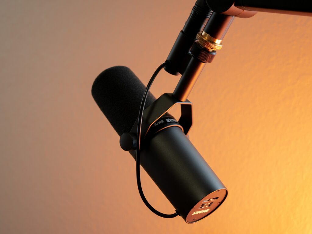 If I'm being honest, this is my *favorite* part of my business. close up of a podcasting microphone against a purple and yellow background